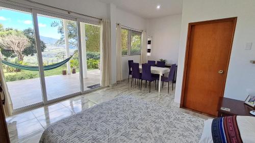 LamasVista Hermosa Lamas的一间卧室，里面有一张床、一张桌子和几把椅子。