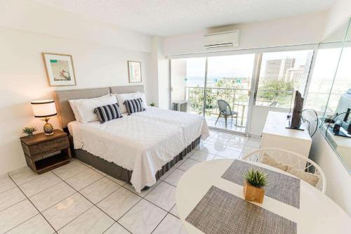 a large bedroom with a bed and a balcony at Waikiki Shore 1014 in Honolulu
