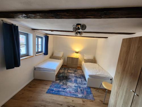 a small room with two beds and a lamp at Fachwerkzeit Haus mit zwei Apartments in Quedlinburg