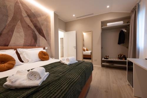 a bedroom with a bed with towels on it at Residenza Galileo -affittacamere Padova sud in Albignasego