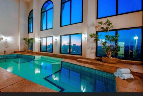 ein großes Schwimmbad in einem Gebäude mit Fenstern in der Unterkunft Hotel Signature Clarion BLUE - Luxury Veranda Edition - by PluXstay in São Paulo