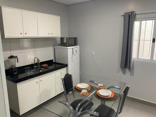 a kitchen with a table with plates on it at Apto Completo - 100m da Av Weyne Cavalcante, Centr in Canaã dos Carajás
