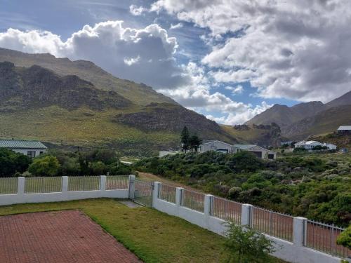 a white fence with mountains in the background at Fijnbos - Something-Els in Rooiels