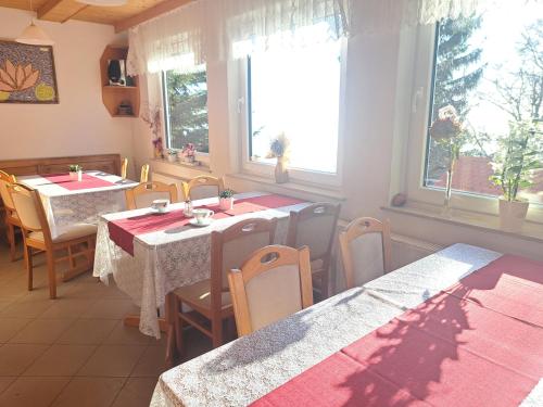 a dining room with tables and chairs and windows at Gostišče Jelka, Hočko Pohorje in Pohorje