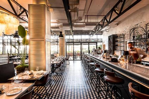 a restaurant with a long bar with tables and chairs at Al Bateen · Ultra Luxury JBR · Private Beach and Pool in Dubai