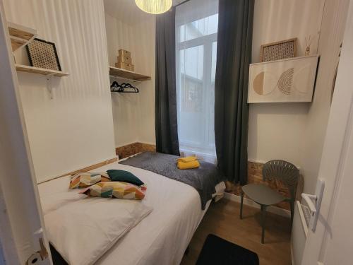 a small bedroom with a bed and a window at Le plein centre rez de chaussee au cœur de Calais in Calais