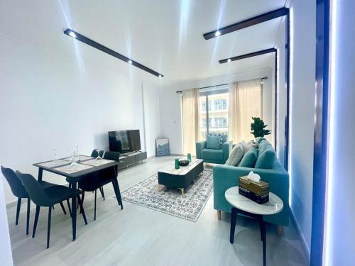 a living room with a blue couch and a table at Marjan Island 1BR Beach Access & Cozy View - Private Exclusive in Ras al Khaimah