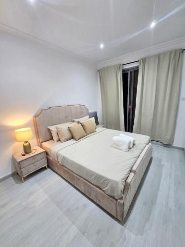 a bedroom with a large bed and a night stand at Marjan Island 1BR Beach Access & Cozy View - Private Exclusive in Ras al Khaimah
