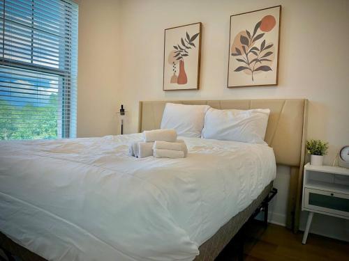 een slaapkamer met een wit bed met twee handdoeken erop bij Modern WorkerFriendly WasherPoolGym Wifi in Sherman