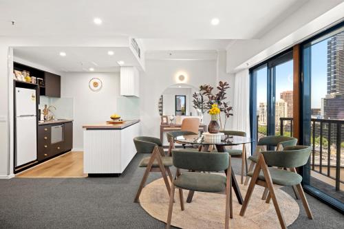 a kitchen and dining room with a table and chairs at 17th on Flinders in Melbourne