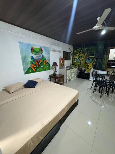Un dormitorio con una cama con un cuadro en la pared. en Pelíkano Uvita, en Uvita