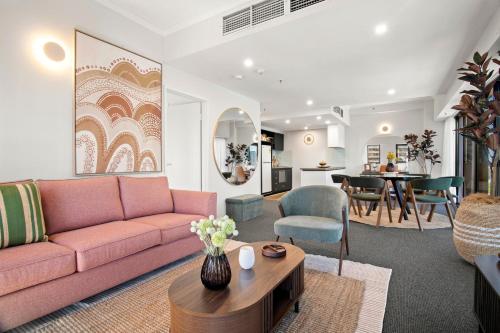a living room with a pink couch and a table at 17th on Flinders in Melbourne