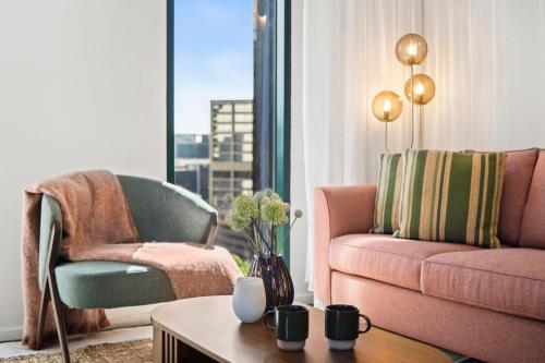 a living room with a couch and a chair and a table at 17th on Flinders in Melbourne