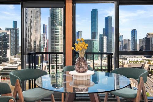 a glass table with chairs and a vase with flowers at 17th on Flinders in Melbourne