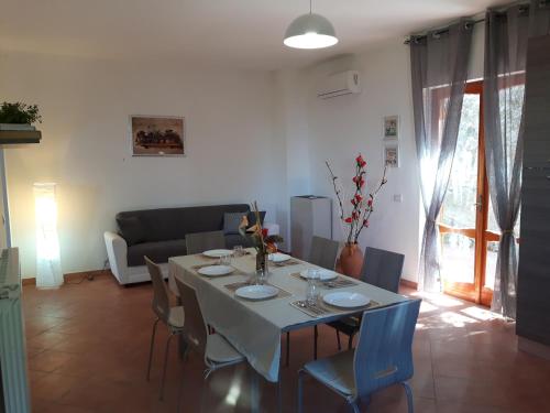 un soggiorno con un tavolo con sedie e un divano di La Casa del Sole a Vico Equense