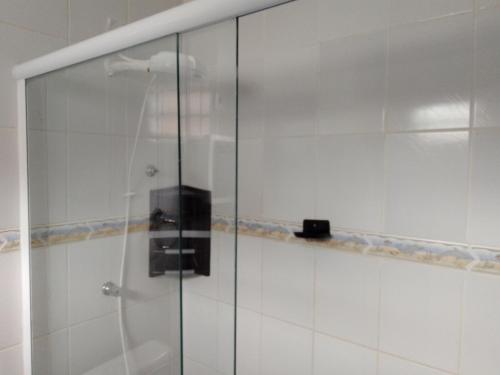 a shower with a glass door in a bathroom at Pink house Enseada Beach in Guarujá