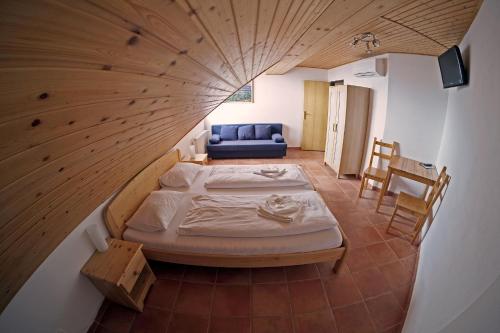 a large room with a bed and a blue couch at Hotel Kreta in Kutná Hora