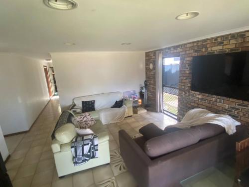 a living room with a couch and a tv at Exclusive Master Bedroom Room with Broadwater views in Gold Coast