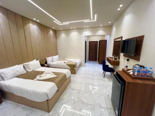 a hotel room with two beds and a television at Glamour Pyramids BoutiQue Hotel in Cairo