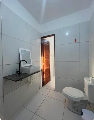 a white bathroom with a toilet and a sink at Apartamento da Kenia in Canoa Quebrada
