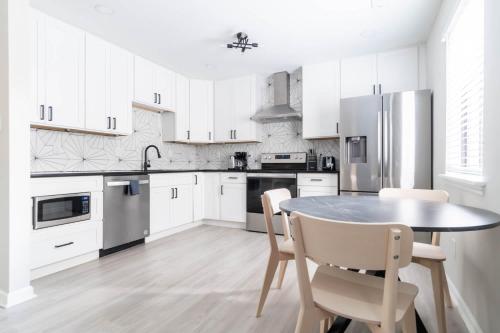 a kitchen with white cabinets and a table and chairs at The Vibe on Durham V 8782 in Durham