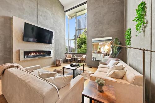 a living room with a couch and a fireplace at New York Style Penthouse in the heart of the city in San Diego