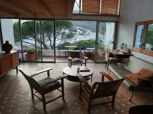 Una sala de estar con un sofá, una mesa y sillas. en Cadaqués Wonderful views central and calm tree house, en Cadaqués