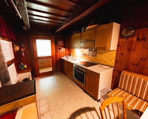 a kitchen with wooden cabinets and a stove top oven at Almhütte am Steirischen Seeberg in Turnau