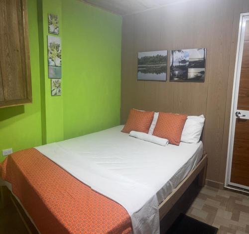 a bed in a room with green walls at Asoagropa in Buenaventura