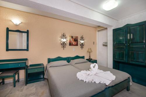 Un dormitorio con una cama con una cómoda y un espejo. en Castle Suites Hotel, en Plataniás
