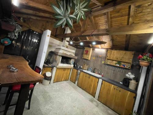 una cucina con armadi in legno e un tavolo in una cabina di къща Горски чар a Beli Osam