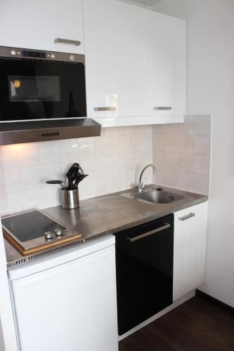 a kitchen with a sink and a microwave at Altineige Appartements VTI in Val Thorens