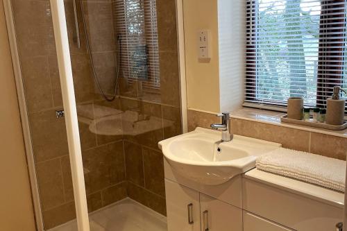 a bathroom with a sink and a shower at Woodside Cottages - Beech cottage - Self-catering in Fletching