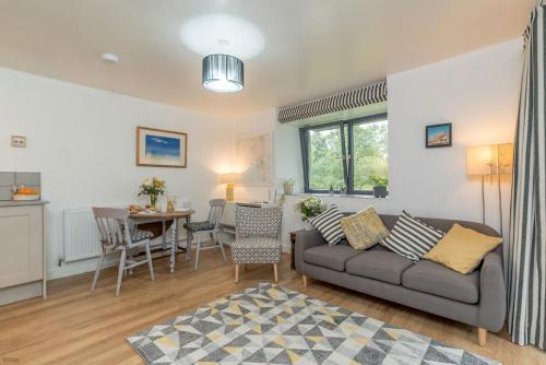 a living room with a couch and a table at Melin-Dwyfor in Criccieth