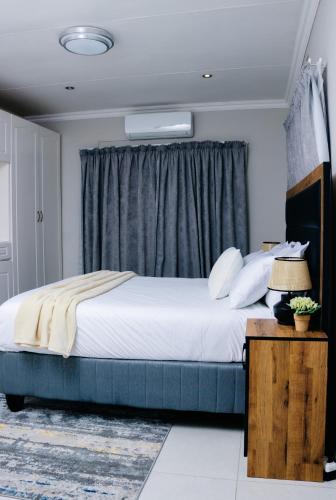 a bedroom with a large bed and a window at The Treat Manzini in Manzini