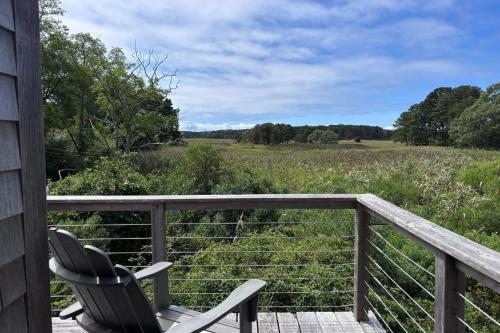 een terras met een stoel en uitzicht op een veld bij Wellfleet Home in Wellfleet