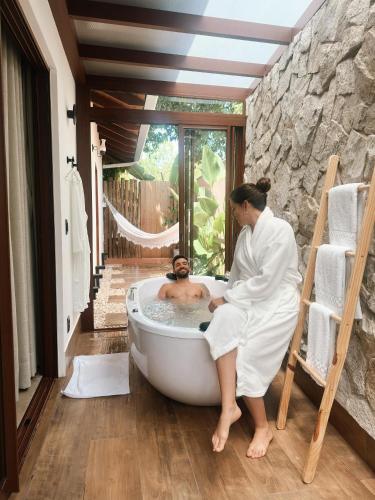 a woman sitting in a bath tub with a man at Vila Inca in Alto Paraíso de Goiás