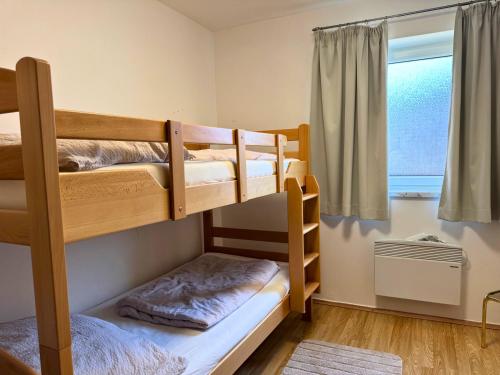 two bunk beds in a room with a window at Salzkammergut Homes Gmunden - Haus im Grünen, Ruhe, großer eingezäunter Garten - ideal für Familien und Hunde in Pinsdorf