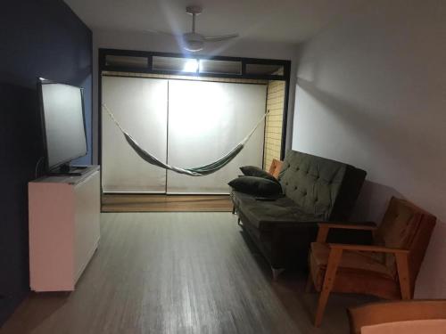 a living room with a couch and a hammock at Apartamento estiloso in Ubatuba