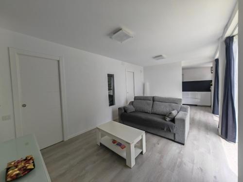 ein Wohnzimmer mit Sofa und Tisch in der Unterkunft Apartamento con vistas al valle in Viladecáns