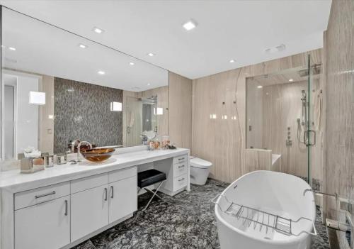 a bathroom with a sink and a tub and a toilet at High-end Coastal Escape in Sunny Isles Beach