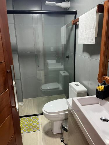 a bathroom with a toilet and a glass shower at Pousada Bella Pantano in Pântano Grande