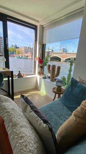 a living room with a view of the river at Houseboat Ark van Amstel in Amsterdam