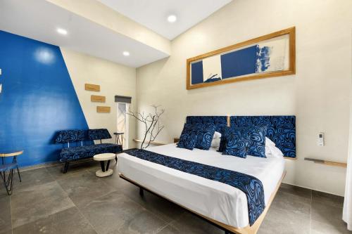 ein Schlafzimmer mit einem großen Bett und einer blauen Wand in der Unterkunft Pierre and Colors TAMARINDO Adults only in Tamarindo