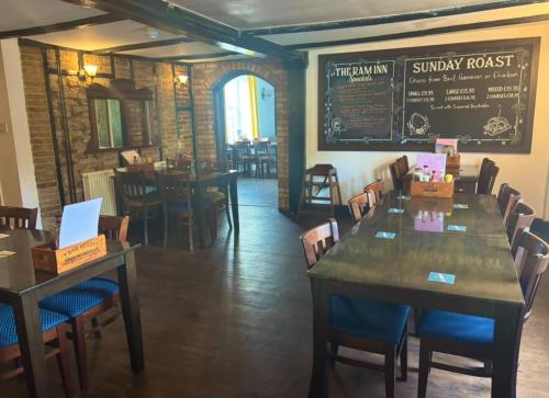 Un comedor con mesas y sillas y una pizarra. en Brandon House, en Brandon