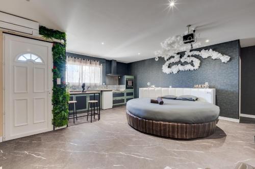 a bedroom with a large bed and a kitchen at Loft Paradis ~Jacuzzi privatif~ Séjour amour in Vieille-Toulouse