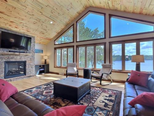 un soggiorno con divano e camino di Northwoods WI 6BR Lakefront Cabin Retreat on Lake Nokomis - Minnohawk Lodge a Tomahawk