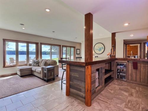 un ampio soggiorno con cucina e divano di Northwoods WI 6BR Lakefront Cabin Retreat on Lake Nokomis - Minnohawk Lodge a Tomahawk