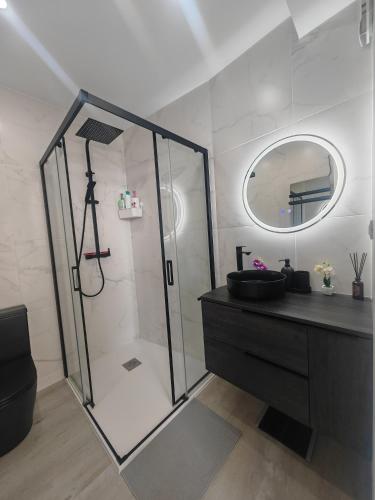 a bathroom with a shower and a sink and a mirror at Apartamento con vistas al valle in Viladecáns