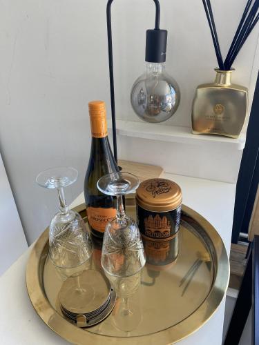 a glass tray with two bottles of wine and glasses at Houseboat Ark van Amstel in Amsterdam